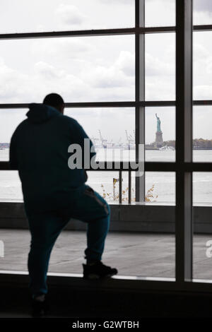 27.10.2015, New York City, New York, USA - Mann wartet auf die Staten Island Ferry, im Hintergrund die Statue of Liberty. 00P151027D286CAROEX. JPG - nicht für den Verkauf in G E R M A N Y, A U S T R I A S W I T Z E R L A N D [MODEL-RELEASE: Nein, PROPERTY-RELEASE: Nein, (C) Caro Fotoagentur / Muhs, http://www.caro-images.com, info@carofoto.pl - jegliche Nutzung dieses Bildes unterliegt GEMA!] Stockfoto