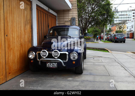 Klassische Volvo PV544 parkten außerhalb Garage, Miraflores, Lima, Peru Stockfoto