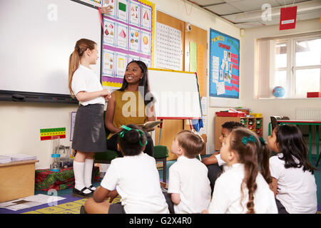 Weibliche Grundschule Schüler lesen vor Klasse Stockfoto