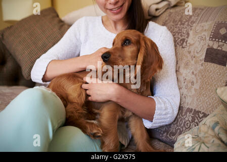 Nahaufnahme von Cocker Spaniel Besitzer kuscheln Hund auf Sofa Stockfoto