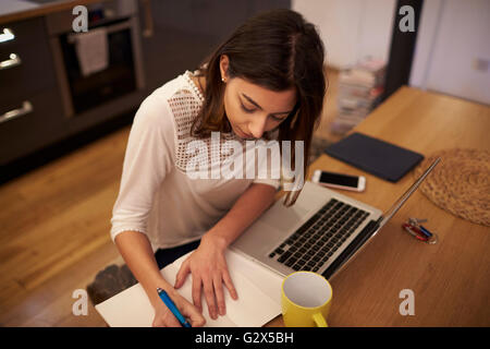 Frau, Arbeit von zu Hause am Laptop In modernen Wohnung Stockfoto