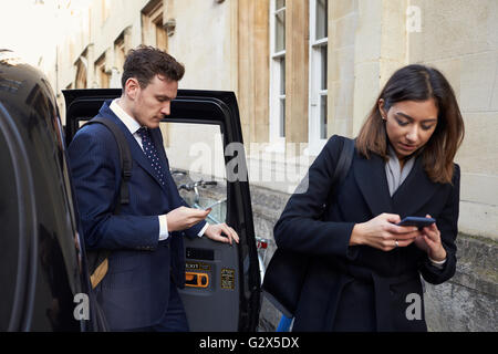 Geschäftsleute aus Taxi mobil telefonieren Stockfoto