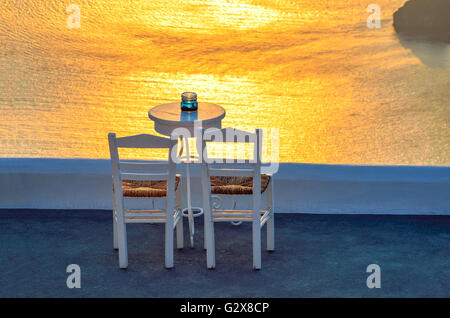 Zwei Stühle und einen kleinen Tisch mit einem herrlichen Blick in Santorini, Griechenland. Stockfoto