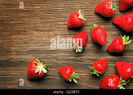 Fresh red strawberries on a wooden background close up. Stockfoto
