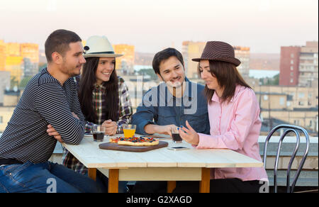 Multi-ethnischen Gesellschaft von jungen Freunden bei Cade Pizzatisch Stockfoto