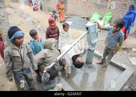 Kinder bei einer Stammes-Kolonie in Westbengalen mit Handpumpe um zu bekommen gebar Brunnenwasser Stockfoto