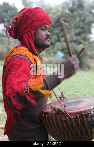 Mitglied einer Stammes-Gemeinschaft in Westbengalen, Schlagzeug zu spielen, während ihre Dorffest Stockfoto