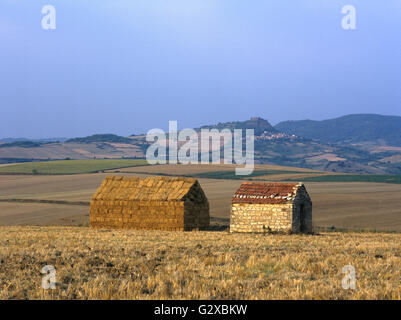 Strohballen Stapeln in der Form eines Hauses neben einem kleinen Steinhaus, Centre, Auvergne, Frankreich Stockfoto