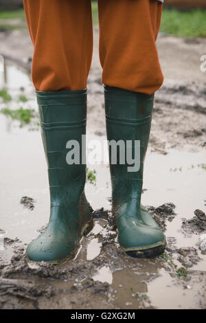 Frauen in Gummistiefel stehen in einer Pfütze Stockfoto
