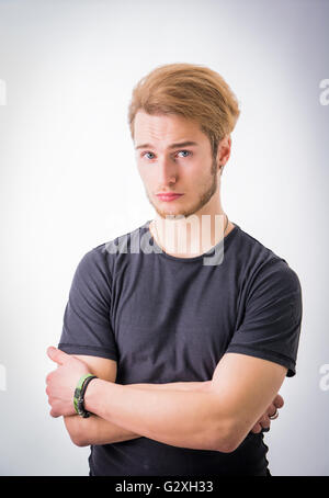 Traurig oder beunruhigt hübscher junger Mann schaut auf hellem Hintergrund Stockfoto