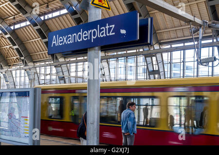 Ein Mann auf dem Bahnsteig als S-Bahn kommt am Alexanderplatz im Berliner Bezirk Mitte an Stockfoto