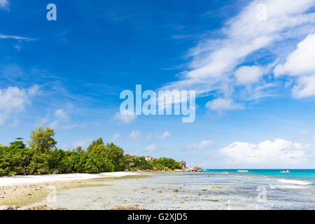 Ebbe am Anse Severe in La Digue, Seychellen mit Palmen und Granit Felsen Stockfoto