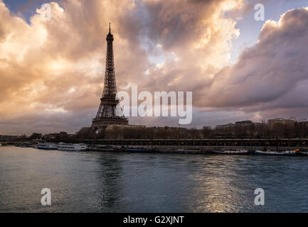 Leuchtende Wolken der Eiffelturm und der Seine bei Sonnenaufgang. Port de Suffren, Paris, Frankreich Stockfoto