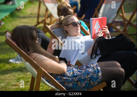 Junge Frauen lesen von Büchern saß in Liegestühlen auf der Hay Festival 2016 Stockfoto