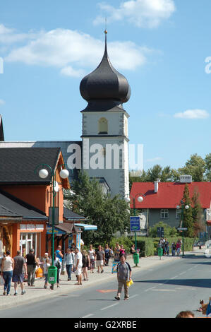 KARPACZ, Polen - 14 AUGUST: Unbekannte Menschen und Kirchturm auf der Hauptstraße in der Stadt Karpacz im Riesengebirge Polen Stockfoto