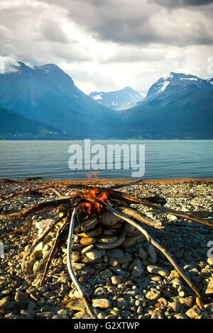 Einladende Lagerfeuer am Strand im Sommer Stockfoto