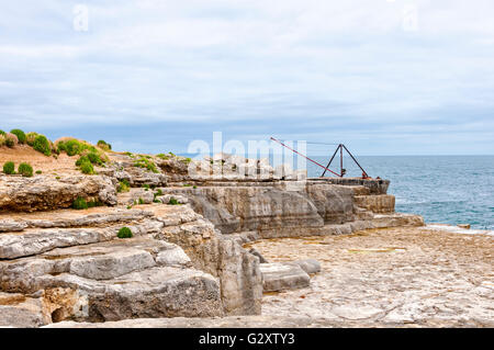 Der rote Kran ist Teil der jetzt stillgelegten Portland Bill Stein Verladungskai auf der Klippe am südlichsten Punkt von Portland Stockfoto