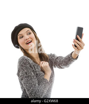 Junge Frau, die eine Selfie mit einem Smartphone vor einem weißen Hintergrund isoliert. Stockfoto