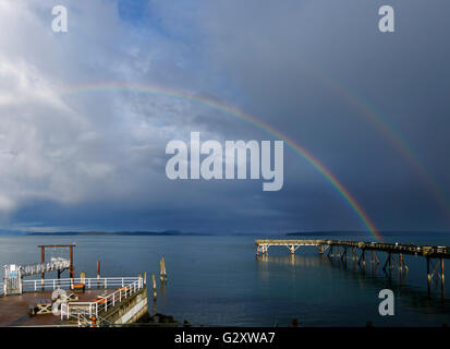 Sidney, British Columbia am Wasser. Ein Regenbogen über dem Fishing Pier im Frühjahr. Stockfoto