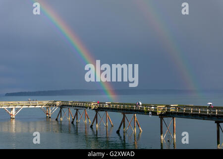 Sidney, British Columbia am Wasser. Ein Regenbogen über dem Fishing Pier im Frühjahr. Stockfoto