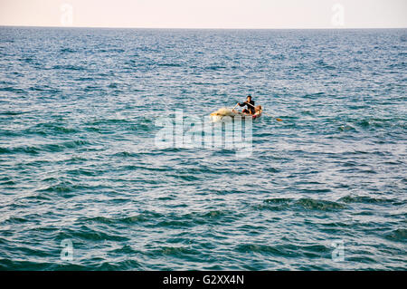 Ein Fischer-Reihen heraus zum Meer in einem kleinen Schlauchboot Stockfoto