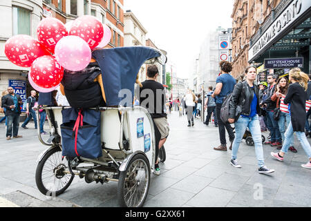 Ein Rikscha-Fahrer wartet auf seinen Tarif vor dem Hippodrome Casino in Londoner Leicester Square, Großbritannien Stockfoto