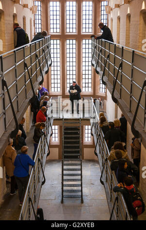 Führer in historischen Kleid / Rollenspiel spricht mit einer Reisegruppe / touristische Gruppen von Touristen in Lincoln Castle viktorianischen Gefängnis. Stockfoto