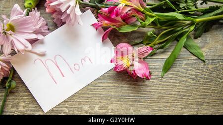 Muttertagskarte mit einem Blumenstrauß. Umschlag mit handgeschriebenen Etikett und einem Bouquet von frischen Blumen in Panorama Ausrichtung. Schuss Stockfoto