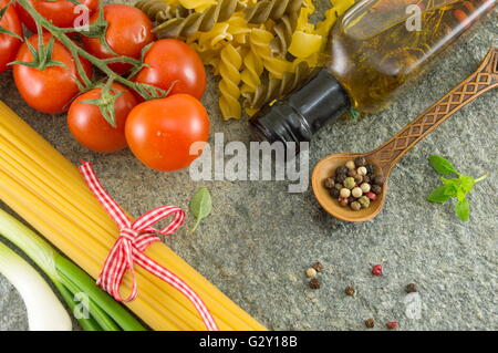 Ungekochte Spaghetti Nudeln mit Gemüse ein Steintisch Stockfoto