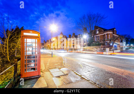 Nacht Szene in Cambridge, Großbritannien, mit roten Telefonzelle und Bewegungsunschärfe leichte Wanderwege Stockfoto