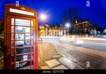 Nacht Szene in Cambridge, Großbritannien, mit roten Telefonzelle und Bewegungsunschärfe leichte Wanderwege Stockfoto