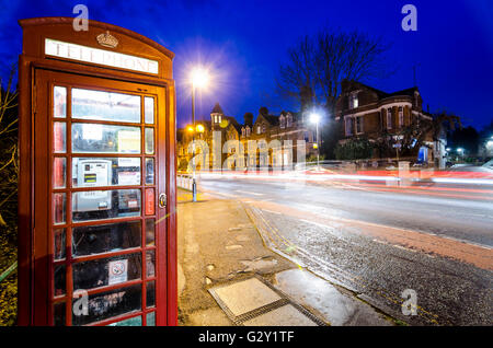 Nacht Szene in Cambridge, Großbritannien, mit roten Telefonzelle und Bewegungsunschärfe leichte Wanderwege Stockfoto
