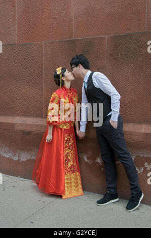 Eine schöne junge asiatische Frau posiert in einem traditionellen chinesischen Brautkleid in Greenwich Village, NYC Stockfoto