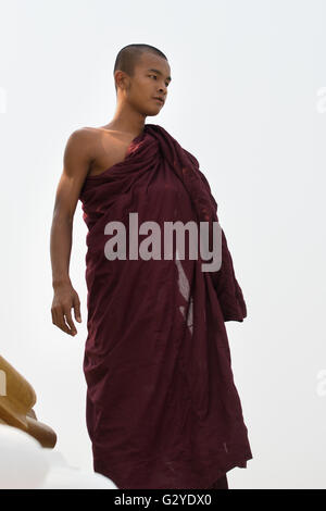 Ein junger Mönch auf der Spitze eines Stupa während der Einweihung einer neuen Pagode, Demoso, Kayah State in Myanmar Stockfoto