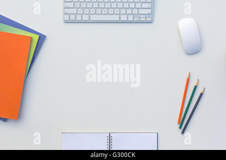 Kreativbüro hell Tisch mit passenden Farbe Zeitschriften und Bleistifte, Computer und Notizblock Stockfoto