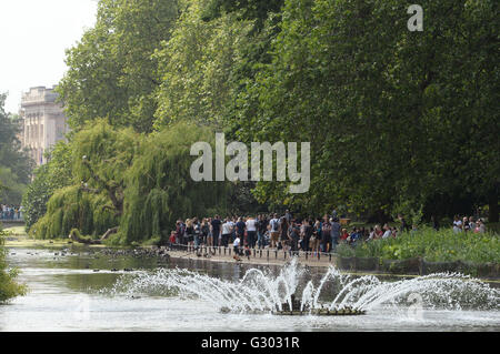 Menschen genießen das warme Wetter in St James' Park, London. Stockfoto