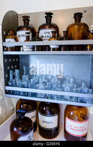 Flaschen in den Regalen in einer Arztpraxis von WW1. Stockfoto