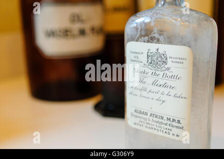 Flaschen in den Regalen in einer Arztpraxis von WW1 darunter eine von Alban Atkin, West Hampstead, England Stockfoto