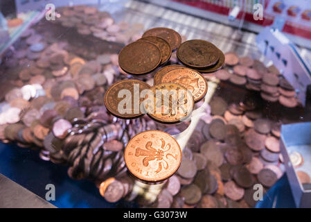 Zwei-Cent-Münzen liegen auf dem Glas auf ein 2P-Nudger-Maschine in eine Spielhalle am Meer. Stockfoto