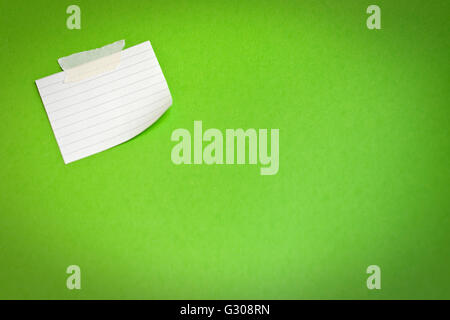 Weiße Notizpapier befestigt auf grünem Hintergrund Stockfoto