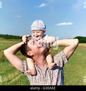 Vater hält ein kleines Kind auf seinen Schultern Stockfoto