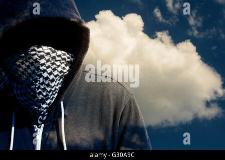 Mit Kapuze und maskierten Computer Hacker Dieb mit einem Cloud-Computer basierten Hintergrund. Unbekannte Technologie Bedrohung für die Cloud-mainframe Stockfoto