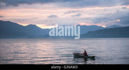 Fischer in einem Fischerboot am Lake Toba (Danau Toba) bei Sonnenaufgang, Nord-Sumatra, Indonesien, Südostasien, Asien Stockfoto