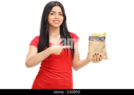 Stets gut gelaunte Frau hält einen Beutel mit Kartoffelchips und zeigt isoliert auf weißem Hintergrund Stockfoto