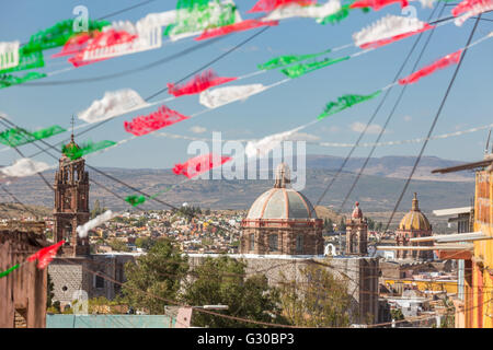 Festliche Papel Picado Banner schmücken eine Straße mit Blick auf die Kirche des Oratorio de San Felipe Neri im historischen Zentrum von San Miguel de Allende, Mexiko. Stockfoto