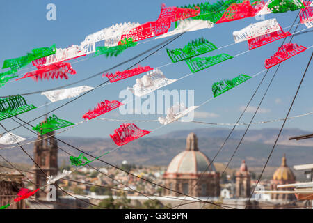 Festliche Papel Picado Banner schmücken eine Straße mit Blick auf die Kirche des Oratorio de San Felipe Neri im historischen Zentrum von San Miguel de Allende, Mexiko. Stockfoto