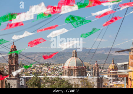 Festliche Papel Picado Banner schmücken eine Straße mit Blick auf die Kirche des Oratorio de San Felipe Neri im historischen Zentrum von San Miguel de Allende, Mexiko. Stockfoto