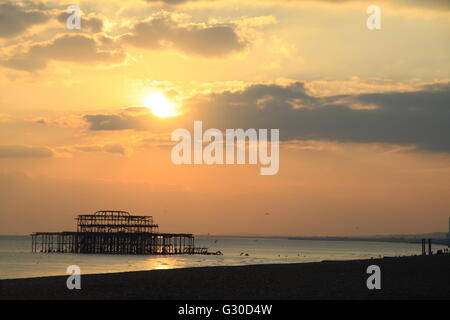 Bleibt der alten Pier von Brighton links stehend im Meer bei Sonnenuntergang, England, UK Stockfoto