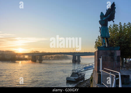 Rhein bei Sonnenaufgang mit Nibelungenbrücke, Frachtschiff, Hagen Memorial, Deutschland, Rheinland-Pfalz, Worms Stockfoto