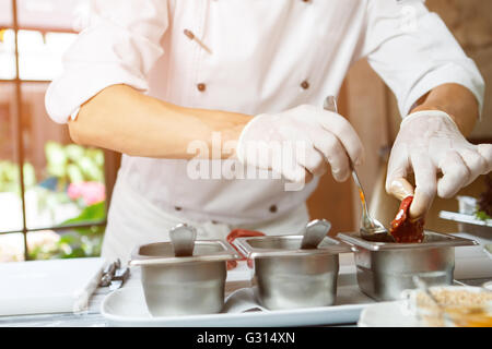 Hände halten Fleisch und Löffel. Stockfoto